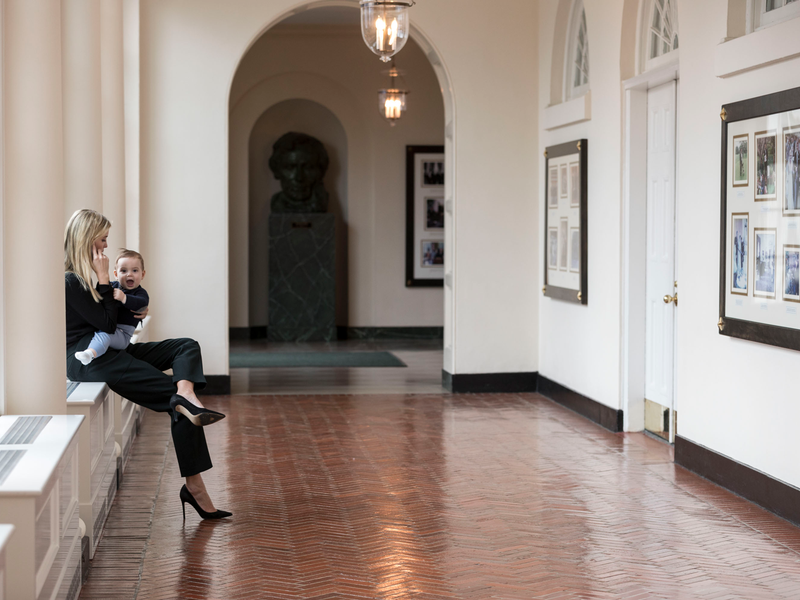 Holding her youngest son Theodore, Ivanka Trump talks on the phone in the East Colonnade of the White House, Sunday, Jan. 29, 2017