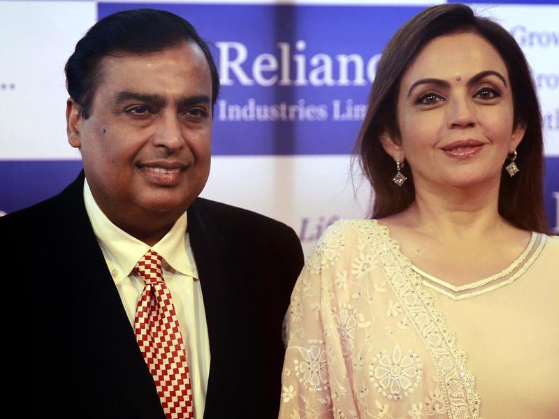 India'slargest private sector company, Reliance Industries chairman Mukesh Ambani, left and his wife Nita Ambani pose for photographs as they arrive for the company's annual general meeting in Mumbai, India, Wednesday, June 18, 2014.